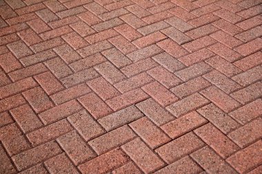 Parlak güneşin altında pembe betondan bir yürüyüş yolu deseni.