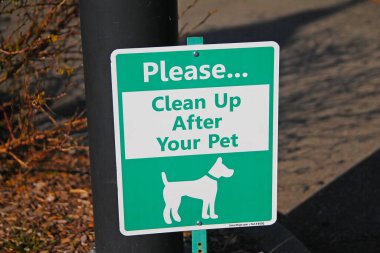 Lütfen, güneşli bir günde evcil hayvanınızın beyaz ve yeşil tabelasını temizleyin.