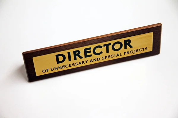 Ofis hayatında gereksiz ve özel projelerin müdürü beyaz bir rafta ahşap ve metal tabela