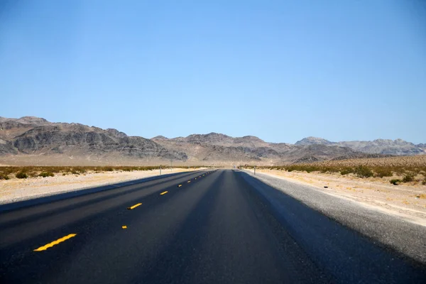 在内华达沙漠的一条长长的街道上 蓝蓝的天空下 有着疯狂的热柏油 — 图库照片