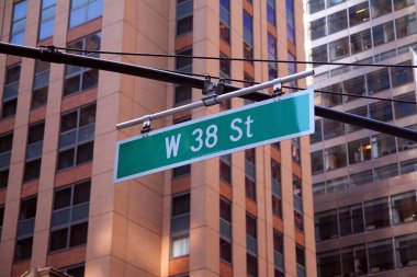 New York 'ta Manhattan şehir merkezindeki caddelerde asılı yeşil büyük batı 38. Cadde tabelası.