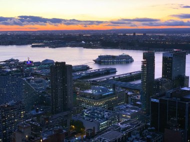 New York 'ta Hudson Nehri' ndeki menekşe bir günbatımında limandan ayrılan bir gezinin dramatik bir görüntüsü.