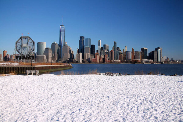 Downtown Manhattan with winter snow on the ground captured from Liberty State Park in Jersey City