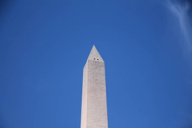 Washington DC 'deki mavi gökyüzündeki beyaz Washington Obelisk anıtı.