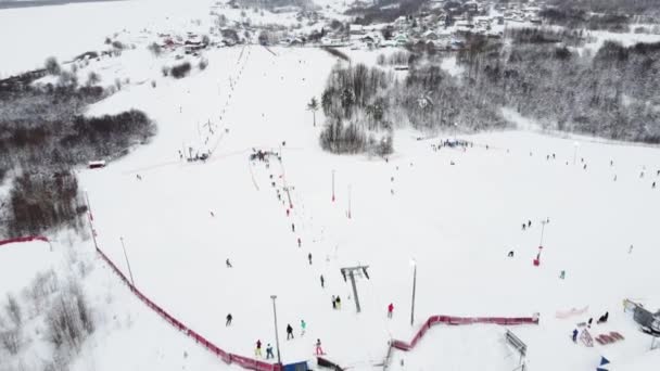 Panoramautsikt från drönare på kabelbanan i skidorten. Skidlift hiss transporterar skidåkare och snowboardåkare på snöig vintersluttning på fjällorten, många människor. UHD 4k video — Stockvideo
