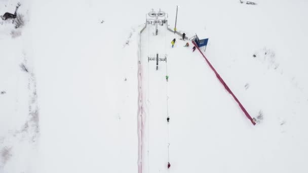 Vista aérea desde un dron de un pequeño pueblo, paisaje invernal, día helado, todo está cubierto de nieve — Vídeos de Stock