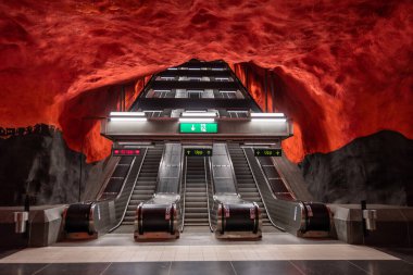 Ocak 2020, modern Stockholm metro istasyonunda İsveç kırmızı renklerinde yürüyen merdiven. Yeraltı