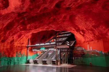 Ocak 2020, modern Stockholm metro istasyonunda İsveç kırmızı renklerinde yürüyen merdiven. Yeraltı