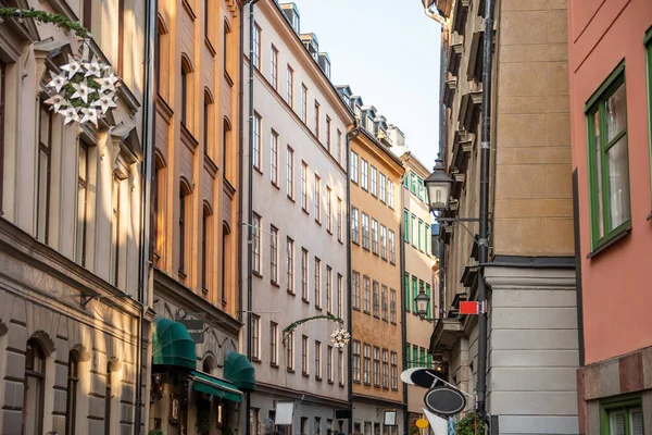 Gamla Stan, Stockholm, İsveç, Ocak 2020 'de sokaklardaki eski evlerin cephelerinde yılbaşı süsleri, şenlikli çelenkler ve yıldızlarla dar sokaklar