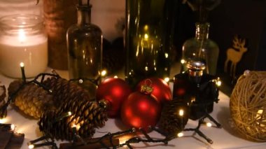 Noel süslemeleri, yanıp sönen ışıklar, 2022 yılının 4k geçmişi. Xmas ağacı kırmızı topları, hediye, mum, köknar kozalakları, şişeler, geyik