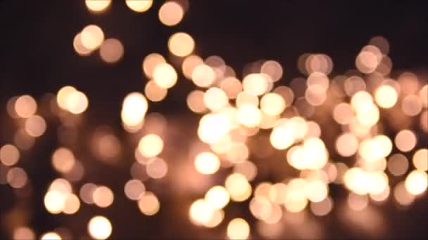クリスマスライト、輝く抽象的な黄金の暖かい円が焦点を絞った。赤い妖精のライト。フォーカス休日の背景のうち。クリスマスツリーからの光のボケ。新年のテーマ、背景4k映像 — ストック動画