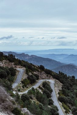 Arka planda kıvrımlı yollar ve dağlar olan hava manzarası