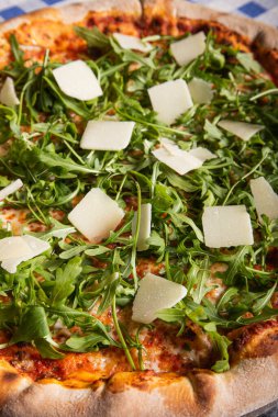 Pizza arkaplanı - domates, roka ve parmesanlı pizzanın makro fotoğrafı.