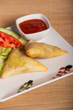 Hint sosuyla servis edilen sebzeli samosa, Pakistan yemeği. Dikey resim.