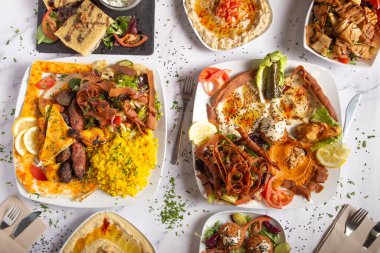 Beyaz arka planda çeşitli Arapça ve Orta Doğu yemekleri. Humus, metabal, Fatoush salatası, falafel. Üst görünüm