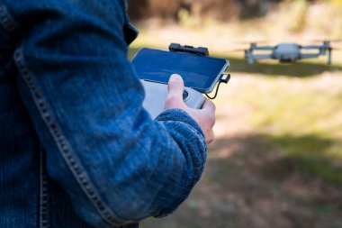 Quadcopter 'ın uzaktan kumandasını elinde tutan adam. İnsansız hava aracının uzaktan kumandası.