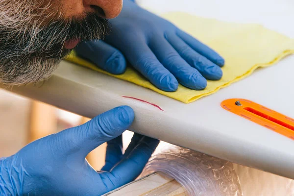 Surfer Repairing Blow Surfboard Royaltyfria Stockbilder