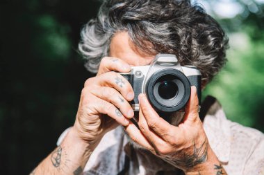 Portrait of a man taking a photo of the viewer with a vintage camera