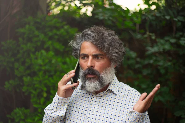 Hipster businessman talking with a worried face on his cell phone
