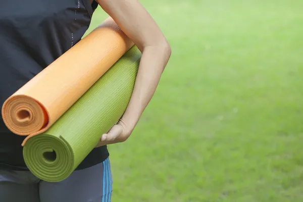 Молодая женщина держит коврики для йоги Стоковое Изображение