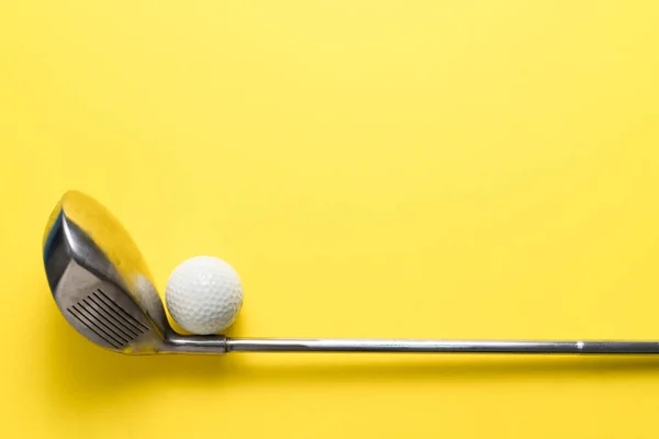 黄色の背景にゴルフボールとゴルフクラブ スポーツの概念 — ストック写真