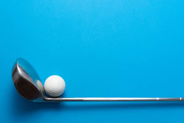 golf ball and golf club on blue background, sport concept