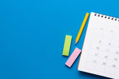 mavi masa arkaplanındaki takvimi kapat, iş toplantısı ya da seyahat planlama konsepti için planlama