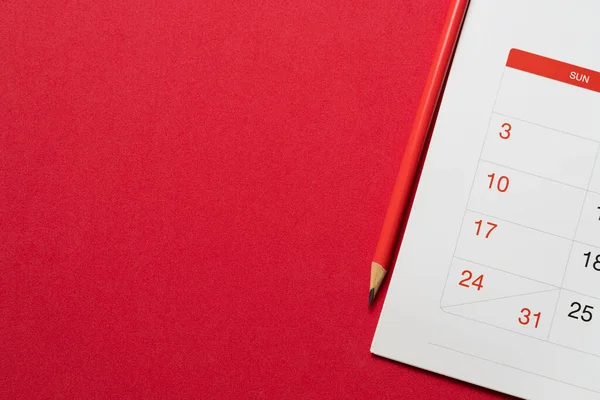Menutup Kalender Dan Pensil Pada Latar Belakang Meja Merah Merencanakan — Stok Foto