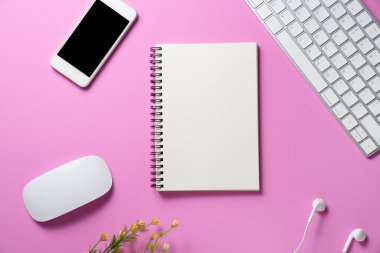 Akıllı telefon, not defteri, dizüstü bilgisayar veya bilgisayar klavyesiyle çalışma masasını kapatın. Pembe kopya alanı arkaplanı, en az stil, yaratıcı düz konsept için