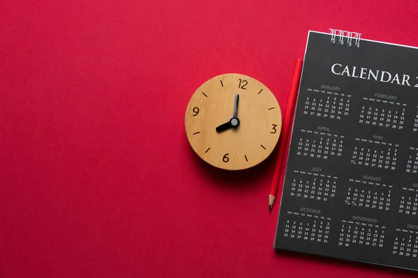 close up of calendar and clock on the red table background, planning for business meeting or travel planning concept