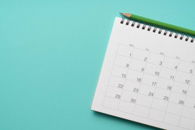 Yeşil masa arkaplanındaki takvim ve kalemi kapat, iş toplantısı ya da seyahat planlama konseptini planla