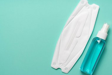 Tıbbi tek kullanımlık yüz maskesi ve alkol spreyi yeşil masa geçmişi, sağlıklı ve ilaç konsepti üzerinde covid-19 veya koronavirüsten korur.