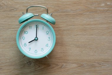 Ahşap masadaki yeşil alarm saati, antika tarzda.