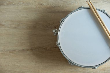 Bateri çubuğu ve davul ahşap masa arkaplanı, üst görünüm, müzik konsepti