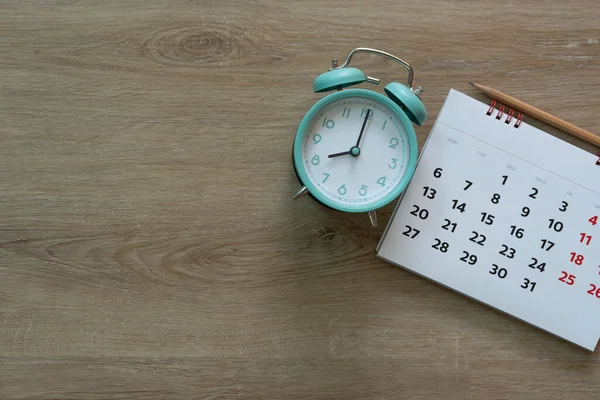关闭木制桌子背景上的日历和闹钟 规划商务会议或旅行规划概念 — 图库照片