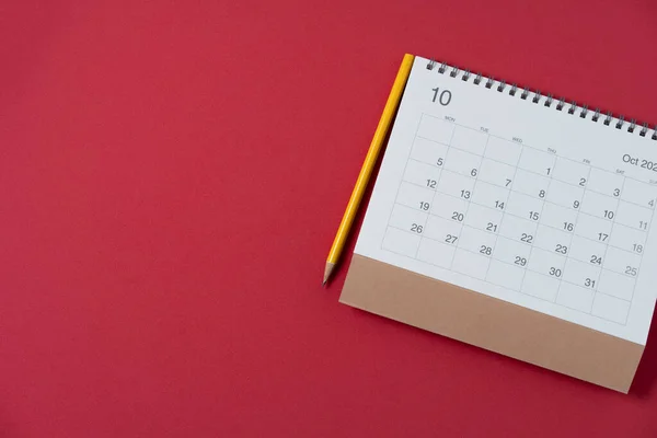 在红色桌子背景 商务会议规划或旅行规划概念上关闭日历和铅笔 — 图库照片
