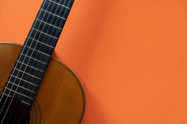 Turuncu masa arkasında eski klasik gitar, müzik konsepti
