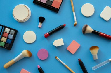 Mavi masa arka planında renkli kozmetik seti