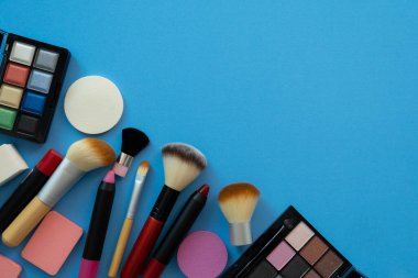 Mavi masa arka planında renkli kozmetik seti