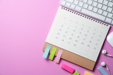 close up of calendar and computer keyboard on the pink table background, planning for business meeting or travel planning concept