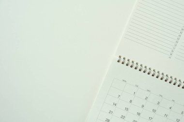 Takvimi beyaz masa arka planında kapat, iş toplantısı ya da seyahat planlama konsepti için planlama