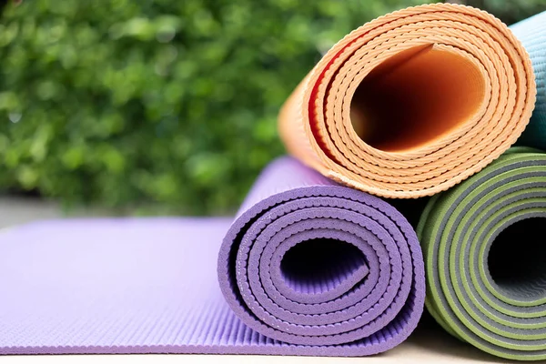 close up of colorful yoga mat on the table, sport and healthy concept