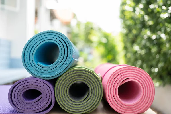 close up of colorful yoga mat on the table, sport and healthy concept