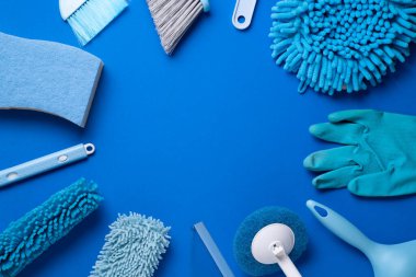 Ahşap masa üzerinde ev temizleme plastik ürünü mavi arka plan, ev servisi veya temizlik konsepti