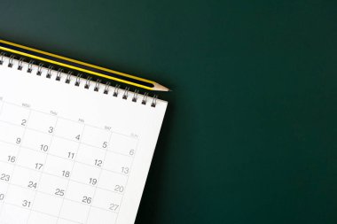 Yeşil masa arkaplanındaki takvim ve kalemi kapat, iş toplantısı ya da seyahat planlama konseptini planla