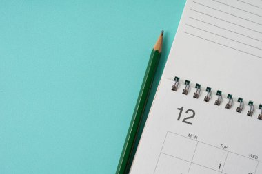 Yeşil masa arkaplanındaki takvim ve kalemi kapat, iş toplantısı ya da seyahat planlama konseptini planla