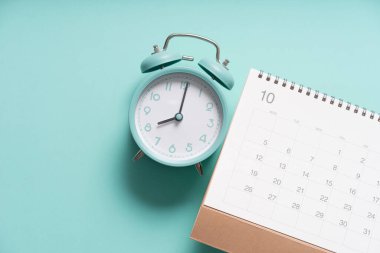 Yeşil masa arkaplanındaki takvim ve alarmın kapatılması, iş toplantısı ya da seyahat planlama konsepti