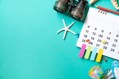 Takvim ve aksesuarları yeşil masa arka planında kapat, seyahat konsepti için planlama