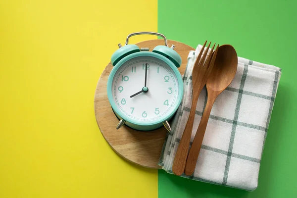 Food clock spoon and fork, Healthy food breakfast concept on colorful table background