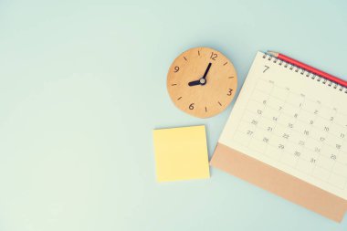 mavi masa arkaplanındaki takvim ve alarmın kapatılması, iş toplantısı ya da seyahat planlama konsepti